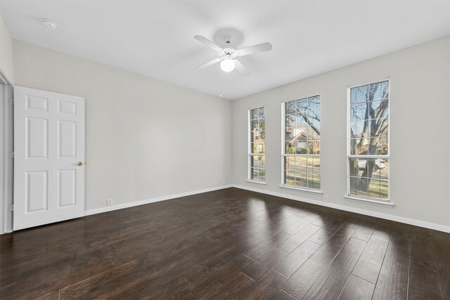 empty room featuring ceiling fan, baseboards, and wood finished floors