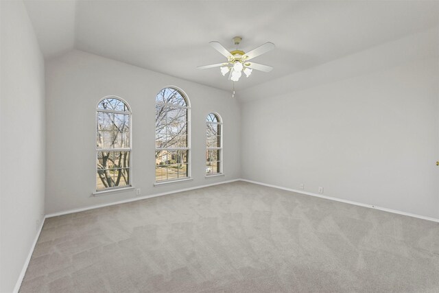 empty room with baseboards, carpet floors, lofted ceiling, and a ceiling fan