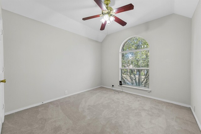 carpeted empty room with baseboards, lofted ceiling, and a ceiling fan