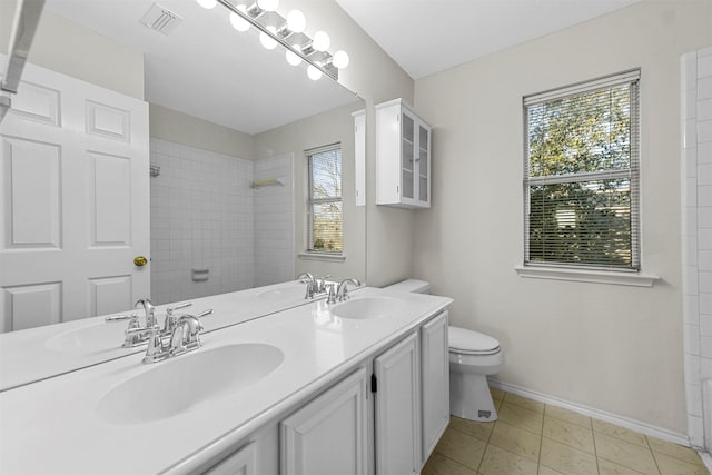 bathroom with toilet, a shower, visible vents, and a sink