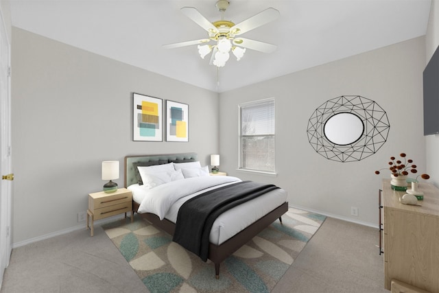 bedroom featuring light colored carpet, a ceiling fan, and baseboards