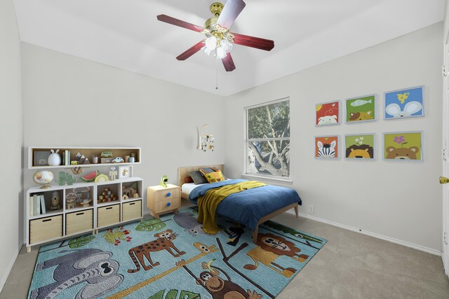 carpeted bedroom featuring baseboards and ceiling fan