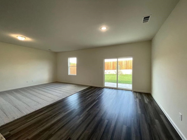 unfurnished room with dark wood-type flooring, recessed lighting, baseboards, and visible vents