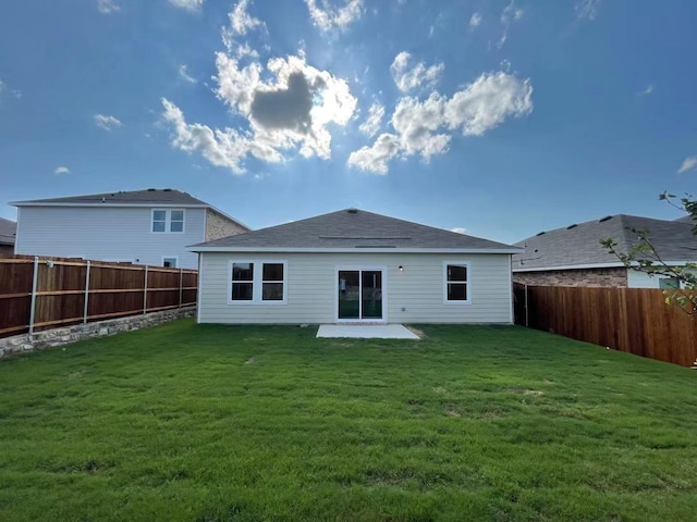 rear view of house with a patio, a lawn, and a fenced backyard