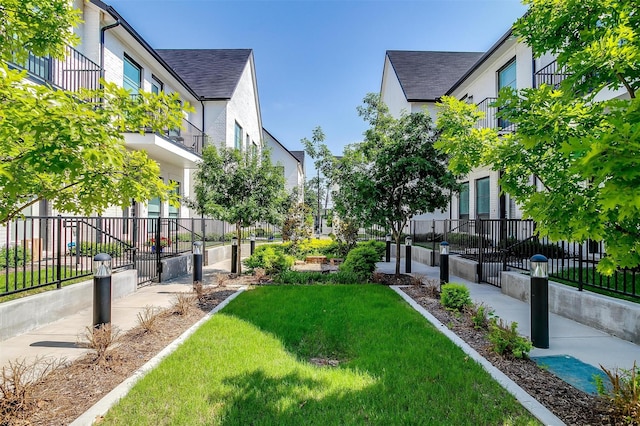 view of home's community with a yard, fence private yard, and a residential view