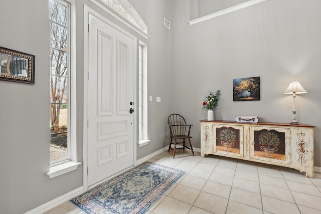 foyer featuring light tile patterned floors, visible vents, and baseboards