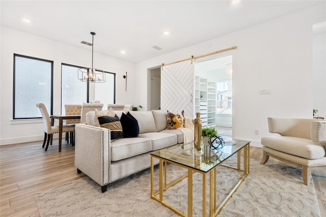 living room featuring visible vents, baseboards, recessed lighting, light wood-style floors, and a notable chandelier