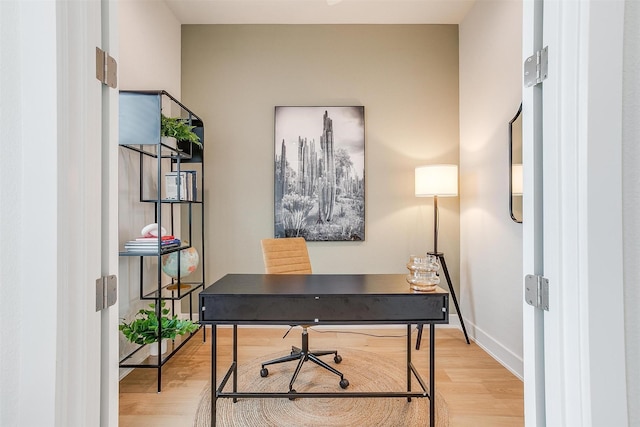 home office with light wood-type flooring and baseboards