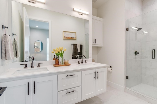 full bath with a sink, marble finish floor, a shower stall, and double vanity