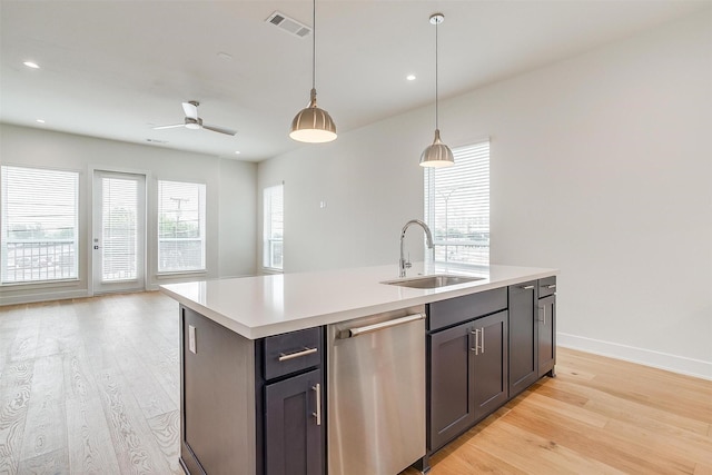 kitchen featuring light wood-style flooring, a sink, light countertops, dishwasher, and open floor plan