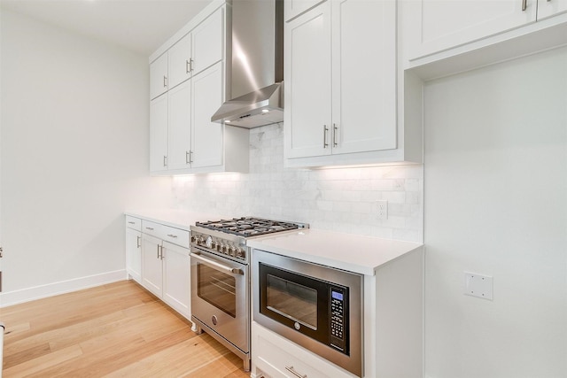 kitchen with high end stainless steel range oven, backsplash, wall chimney exhaust hood, light countertops, and built in microwave