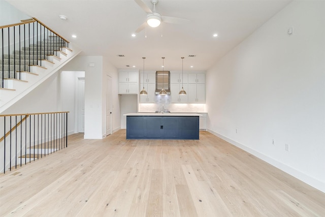 unfurnished living room with light wood finished floors, recessed lighting, baseboards, and ceiling fan