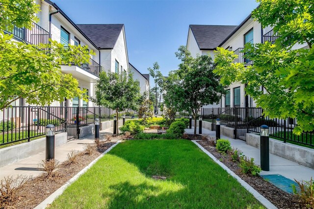 view of community featuring a yard, a residential view, and fence private yard