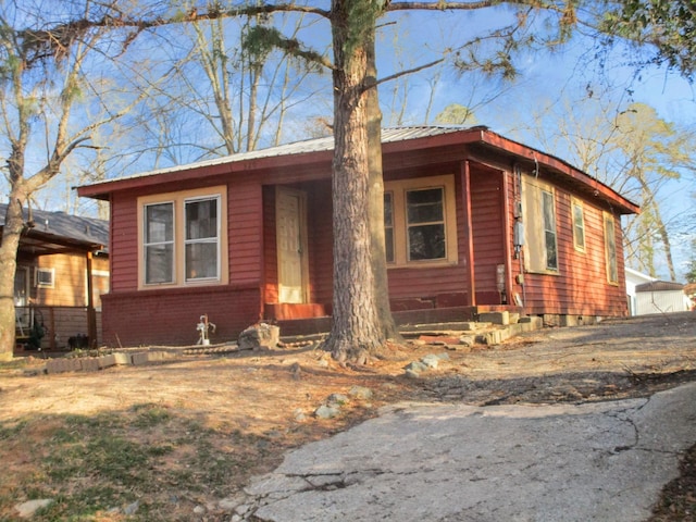 view of front facade featuring brick siding and metal roof