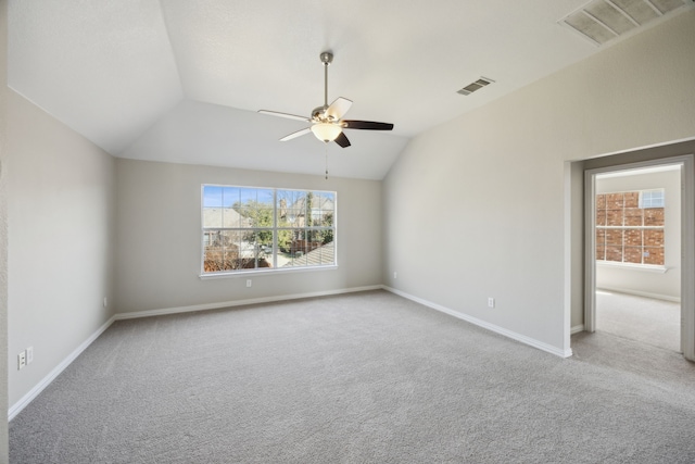 carpeted spare room featuring visible vents, lofted ceiling, baseboards, and a ceiling fan