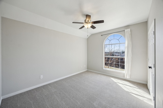 unfurnished room with carpet flooring, a ceiling fan, baseboards, and vaulted ceiling