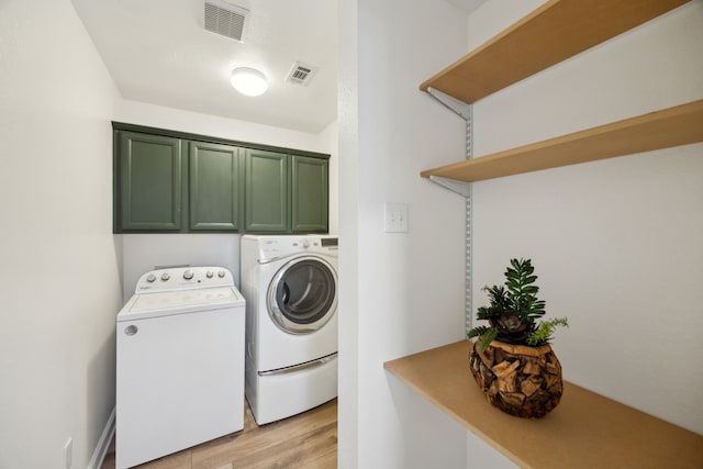 clothes washing area featuring visible vents, cabinet space, light wood-style floors, and separate washer and dryer