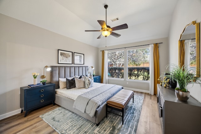 bedroom with vaulted ceiling, light wood-style floors, visible vents, and baseboards