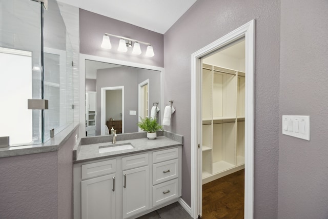 full bathroom featuring vanity and a spacious closet