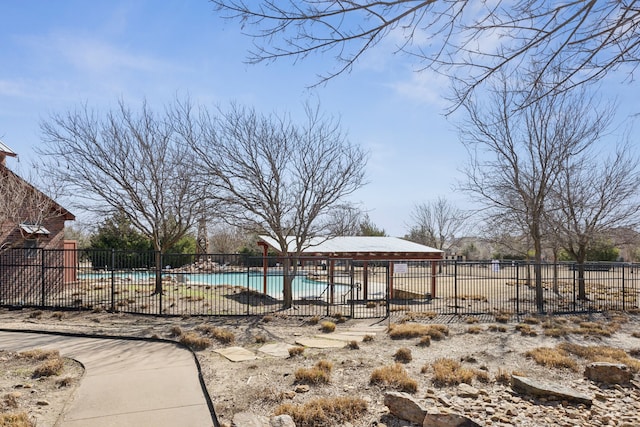 pool with a patio area and fence