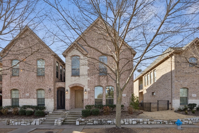 view of front of property featuring fence and brick siding