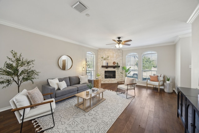 living room with dark wood-style floors, a fireplace, visible vents, and a wealth of natural light