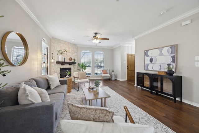 living room featuring baseboards, a stone fireplace, wood finished floors, and ornamental molding