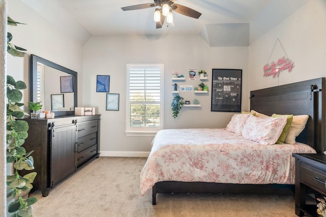 bedroom with light colored carpet, ceiling fan, baseboards, and vaulted ceiling