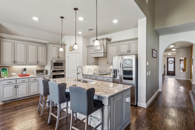 kitchen with visible vents, gray cabinetry, a sink, stainless steel appliances, and arched walkways