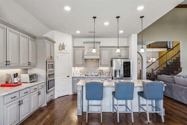 kitchen with visible vents, gray cabinetry, dark wood-style floors, appliances with stainless steel finishes, and custom exhaust hood