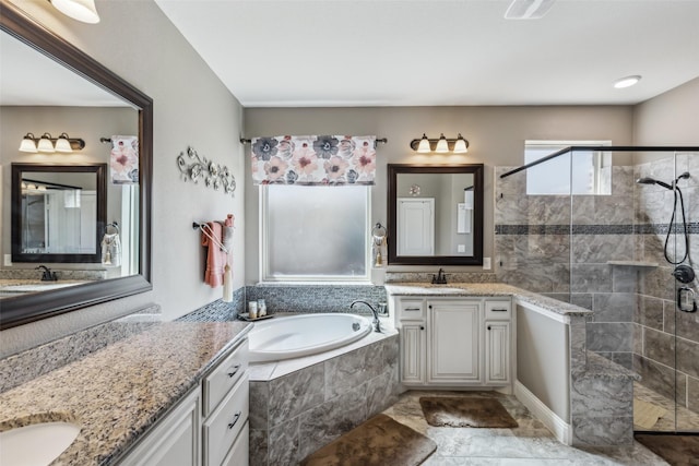 full bathroom featuring a sink, a garden tub, two vanities, and a shower stall