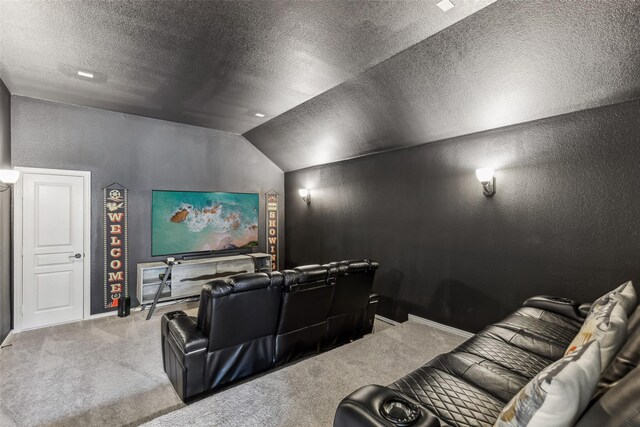 carpeted home theater featuring a textured ceiling, vaulted ceiling, and a textured wall