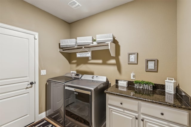 washroom with cabinet space, washing machine and dryer, and visible vents