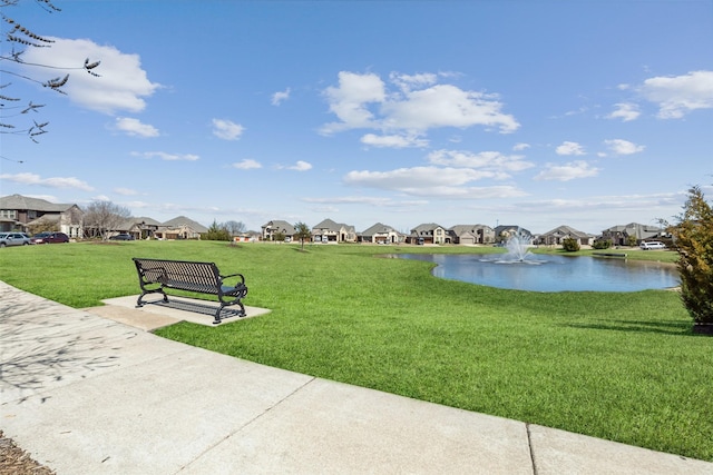 surrounding community with a residential view, a lawn, and a water view