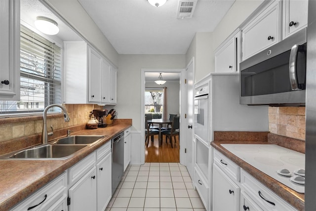 kitchen featuring white cabinetry, a healthy amount of sunlight, stainless steel appliances, and a sink