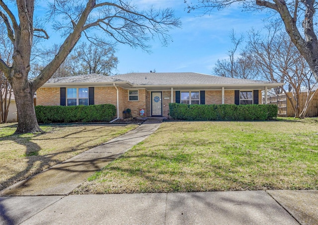 ranch-style home with brick siding, a front yard, and fence