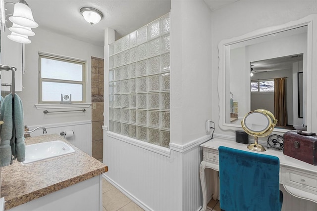 full bath with a wainscoted wall, vanity, and tile patterned flooring