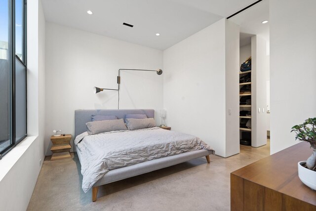 bedroom featuring recessed lighting and concrete flooring