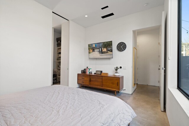 bedroom with recessed lighting and finished concrete flooring