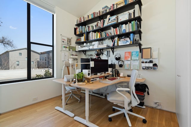 office with wood finished floors and a healthy amount of sunlight