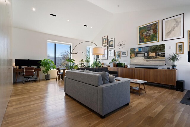 living room featuring high vaulted ceiling and wood finished floors