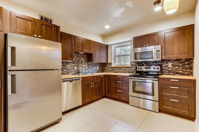 kitchen featuring visible vents, a sink, light countertops, appliances with stainless steel finishes, and backsplash