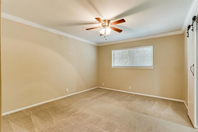 unfurnished room featuring baseboards, ceiling fan, ornamental molding, a barn door, and light colored carpet