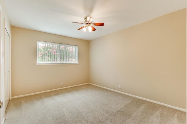 spare room featuring baseboards, ceiling fan, and carpet floors