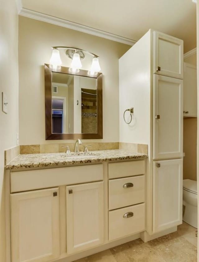 bathroom featuring vanity, toilet, and crown molding