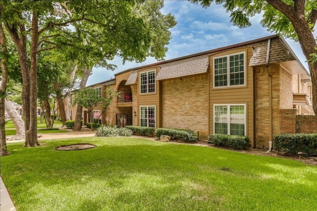 rear view of house with a yard and brick siding