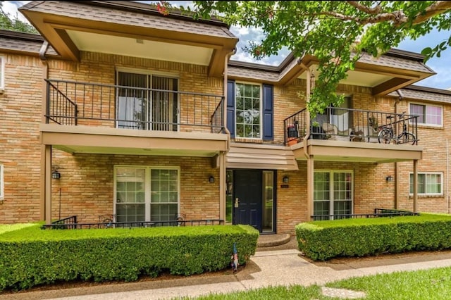 view of front of home featuring a balcony and brick siding