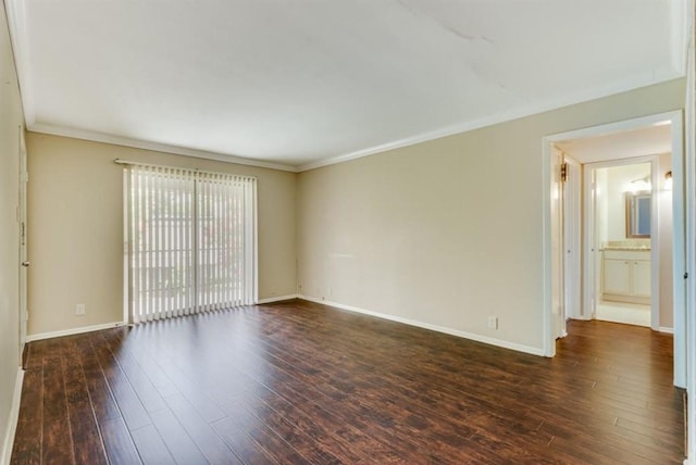 spare room featuring dark wood-style floors, baseboards, and ornamental molding