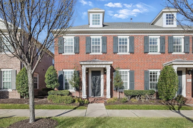 colonial-style house with brick siding