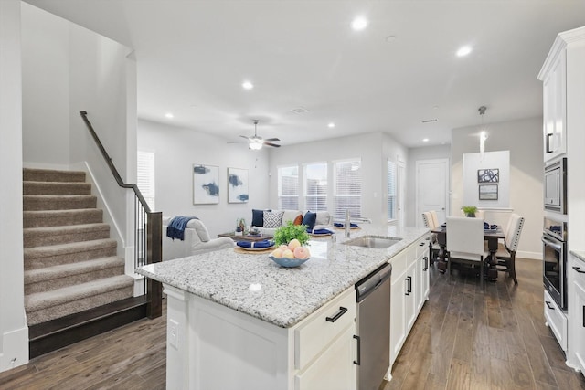 kitchen with white cabinetry, dark wood-style floors, a center island with sink, and stainless steel appliances